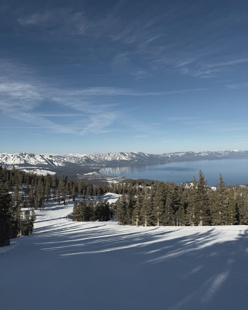 Lake Tahoe and snowy mountains from the top of a ski run