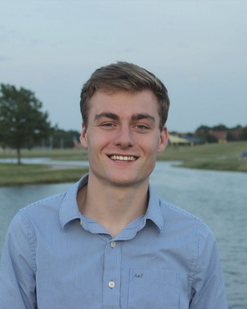 Max Smith in high school, smiling by a pond in Iowa, 2016