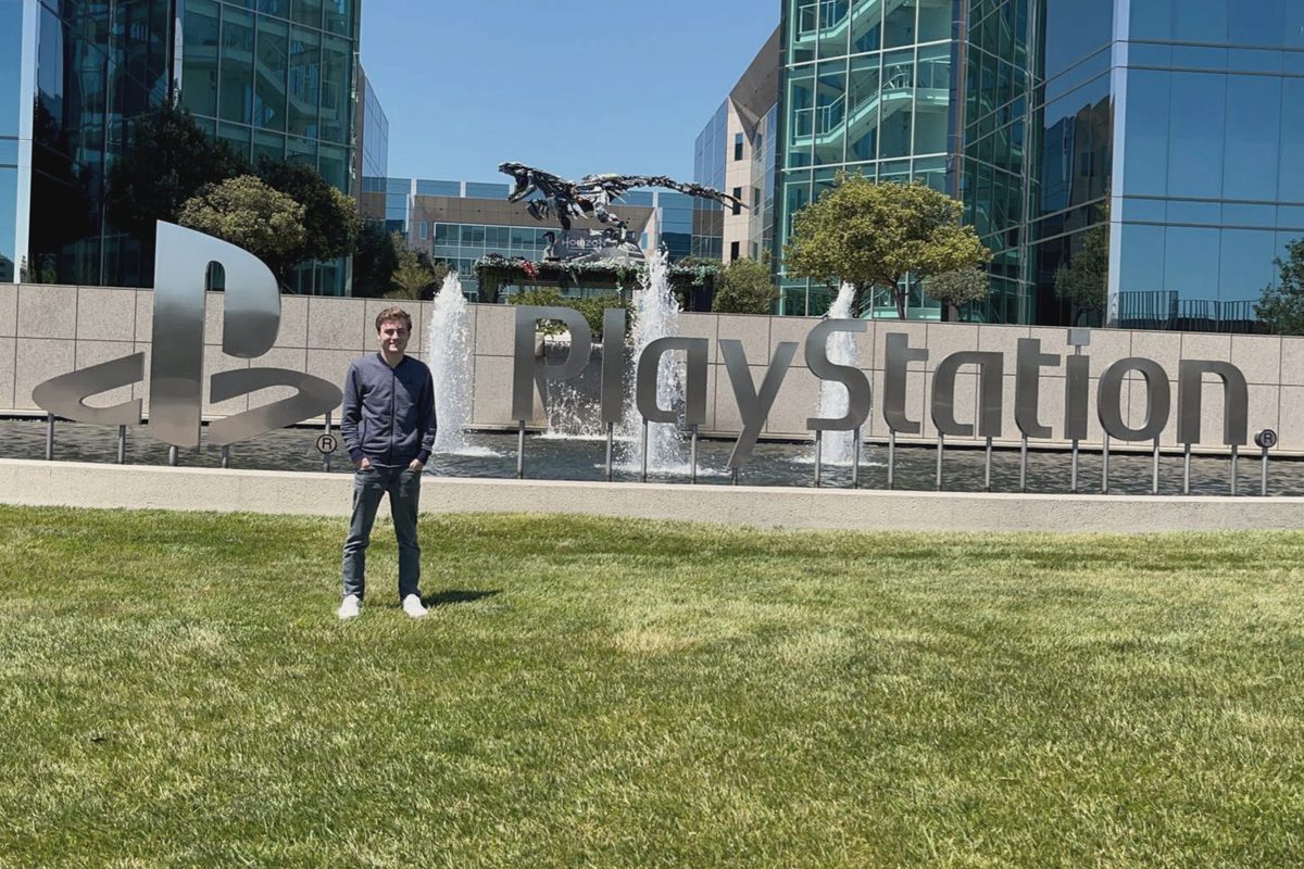 Max Smith beside the PlayStation sign in 2022, the year he joined PlayStation
